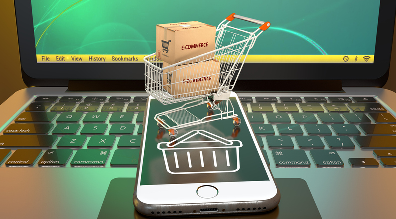 Carrito de compra con cajas de e-commerce sobre un smartphone y un portátil, representando una tienda online